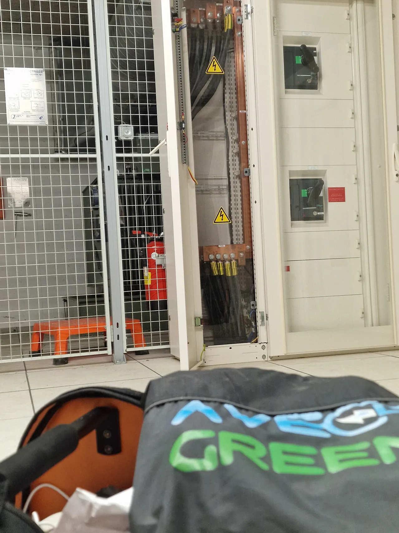 Technicien ave green devant une armoire électrique ouverte