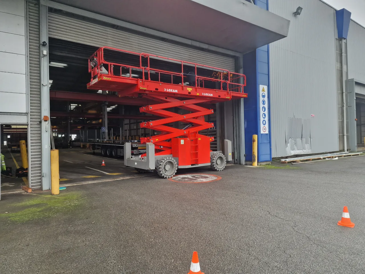 Intervention sur une grande porte industrielle avec une plateforme élévatrice